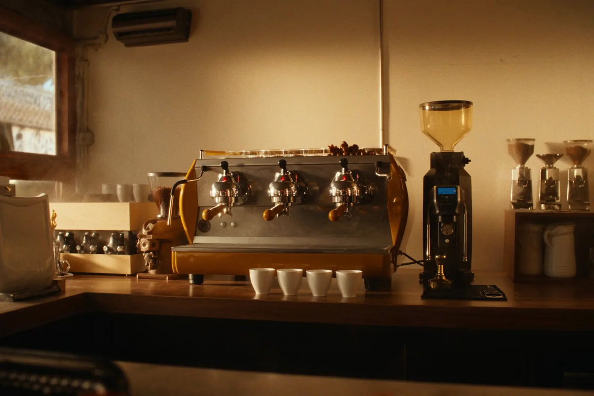 Three-group commercial espresso machine on café bar at golden hour