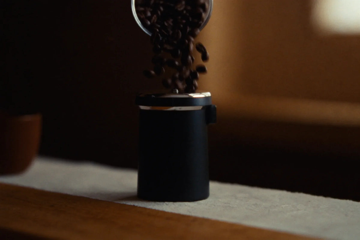 Vertical commercial coffee grinder on professional café bar in warm light