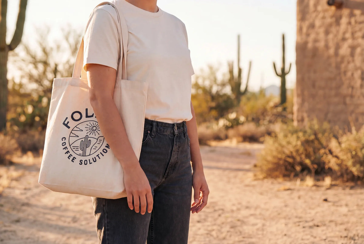 Person wearing Folka t-shirt and tote bag in warm Mexican desert light